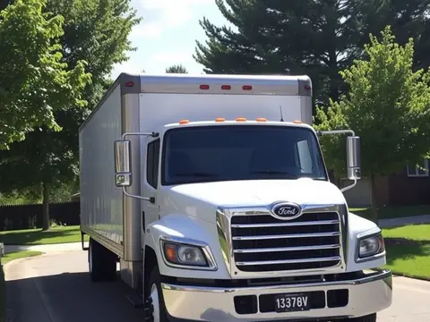 White box truck parked on a residential street lined with pine trees